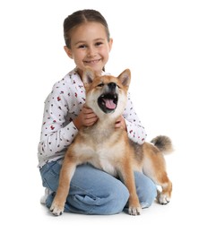 Photo of Smiling little girl with her dog on white background. Child and pet