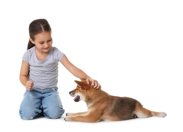 Photo of Smiling little girl stroking her dog on white background. Child and pet