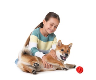 Photo of Smiling little girl playing with her dog on white background. Child and pet