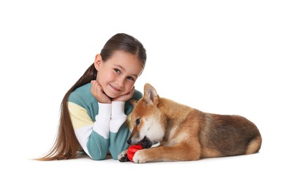 Photo of Cute little girl and her dog with pet toy on white background