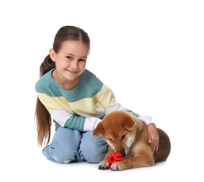 Photo of Smiling little girl and her dog with pet toy on white background