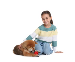 Photo of Smiling little girl and her dog with pet toy on white background