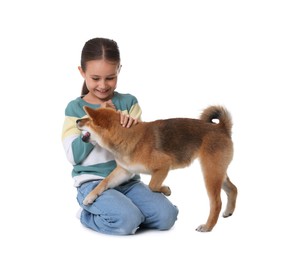 Photo of Smiling little girl with her dog on white background. Child and pet