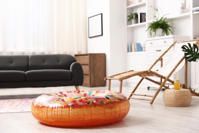 Photo of Bright inflatable donut shaped ring on wooden floor at home. Dreaming about vacation at sea