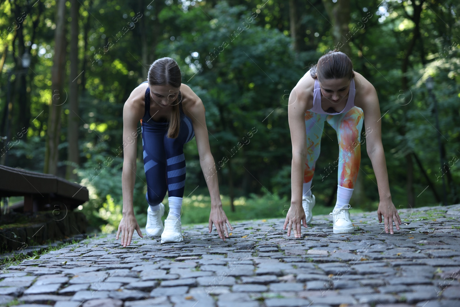 Photo of Young woman running with professional personal trainer outdoors