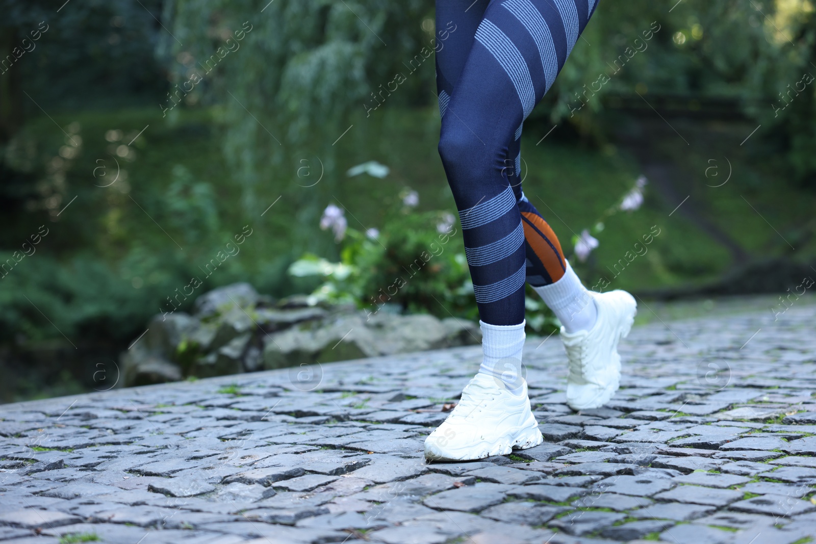 Photo of Young woman with stylish shoes running outdoors, closeup. Space for text