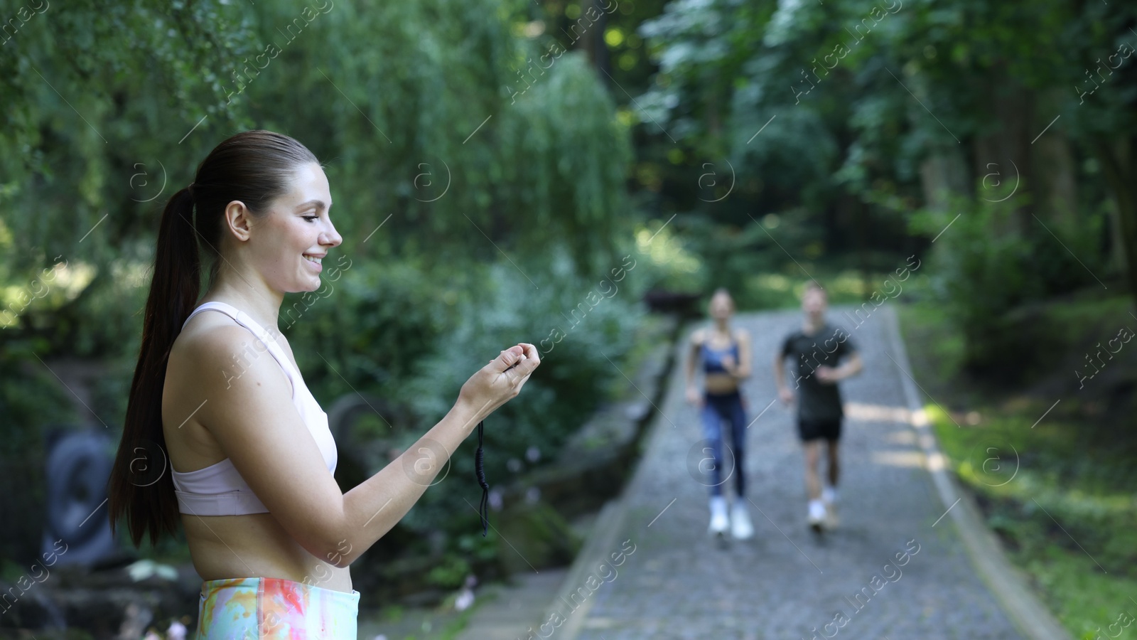 Photo of Young man and woman exercising with professional personal trainer outdoors, selective focus