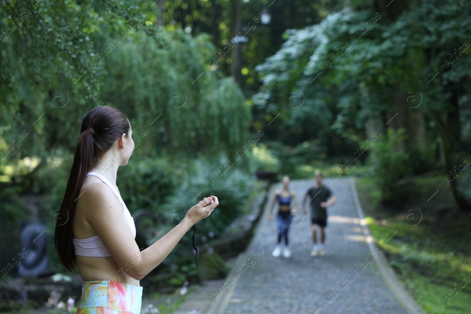 Photo of Young man and woman exercising with professional personal trainer outdoors, selective focus