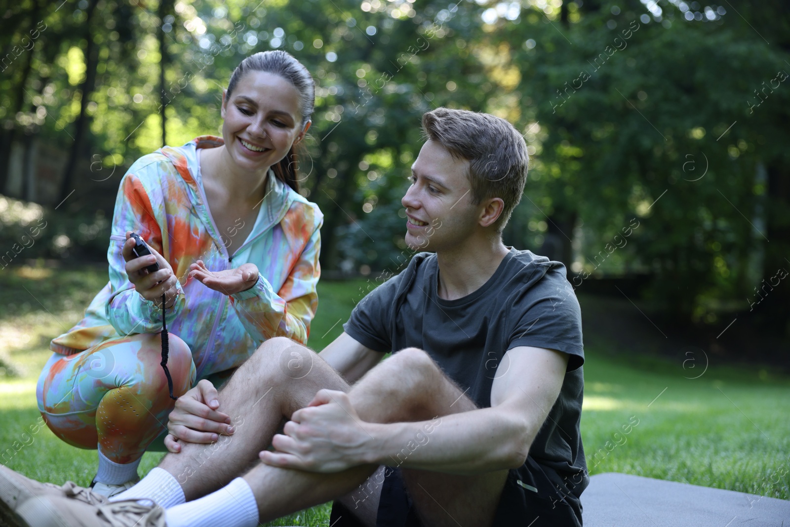 Photo of Young man exercising with professional personal trainer outdoors
