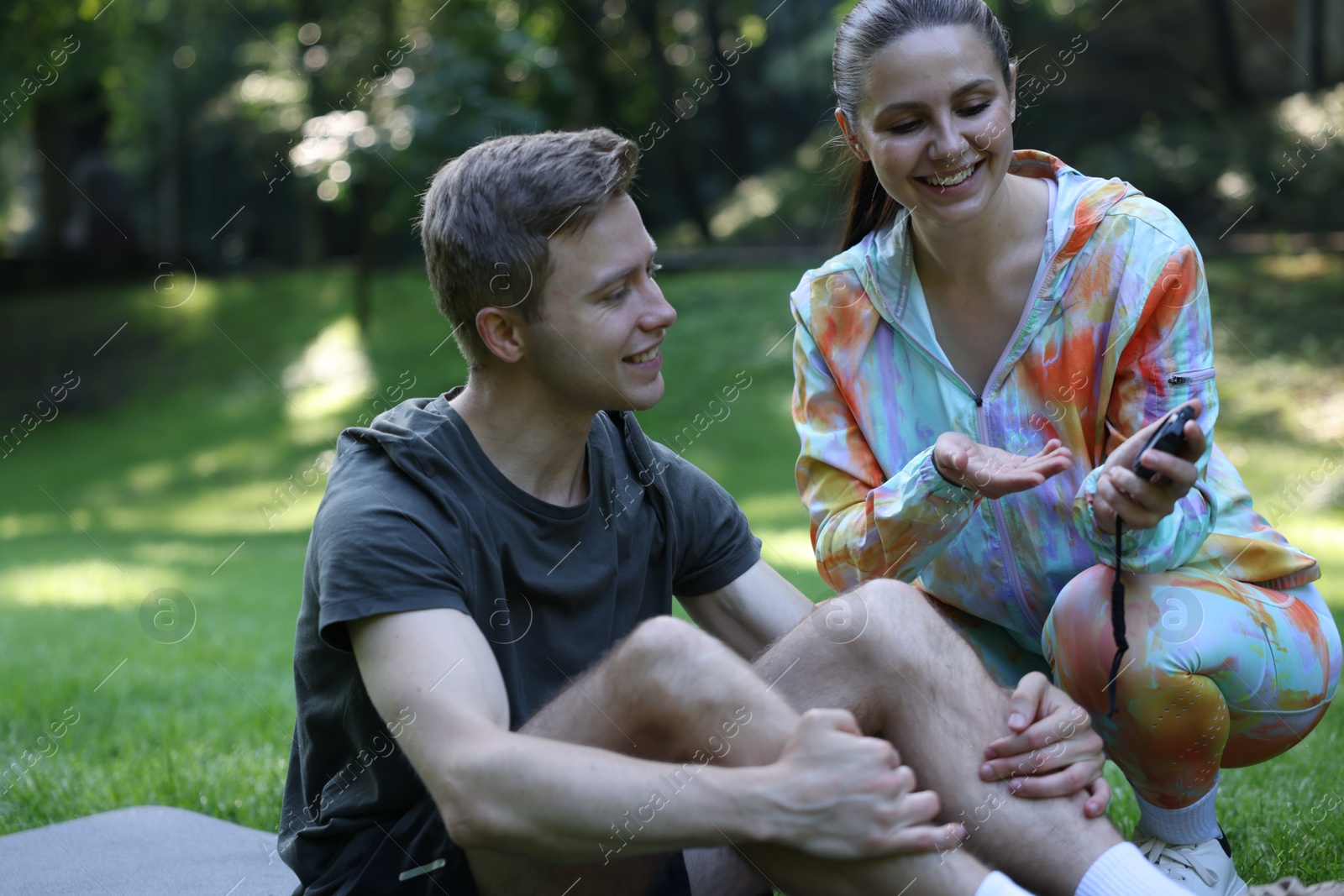 Photo of Young man exercising with professional personal trainer outdoors