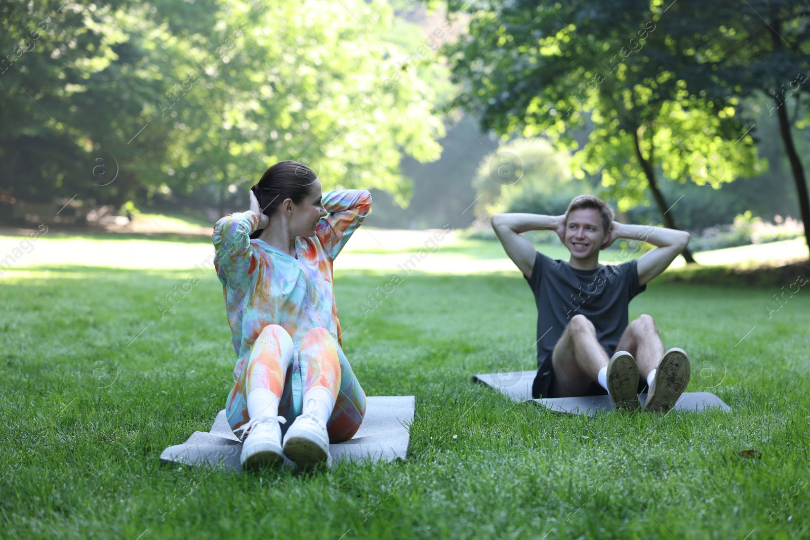 Photo of Young man exercising with professional personal trainer outdoors