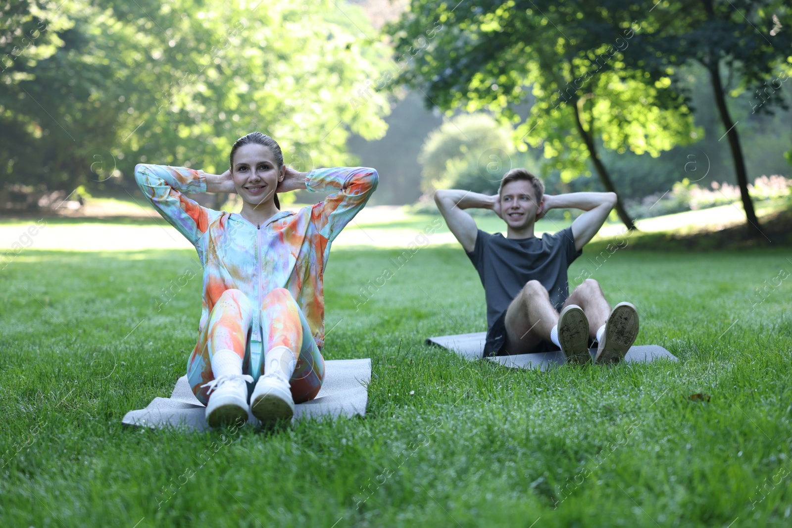 Photo of Young man exercising with professional personal trainer outdoors