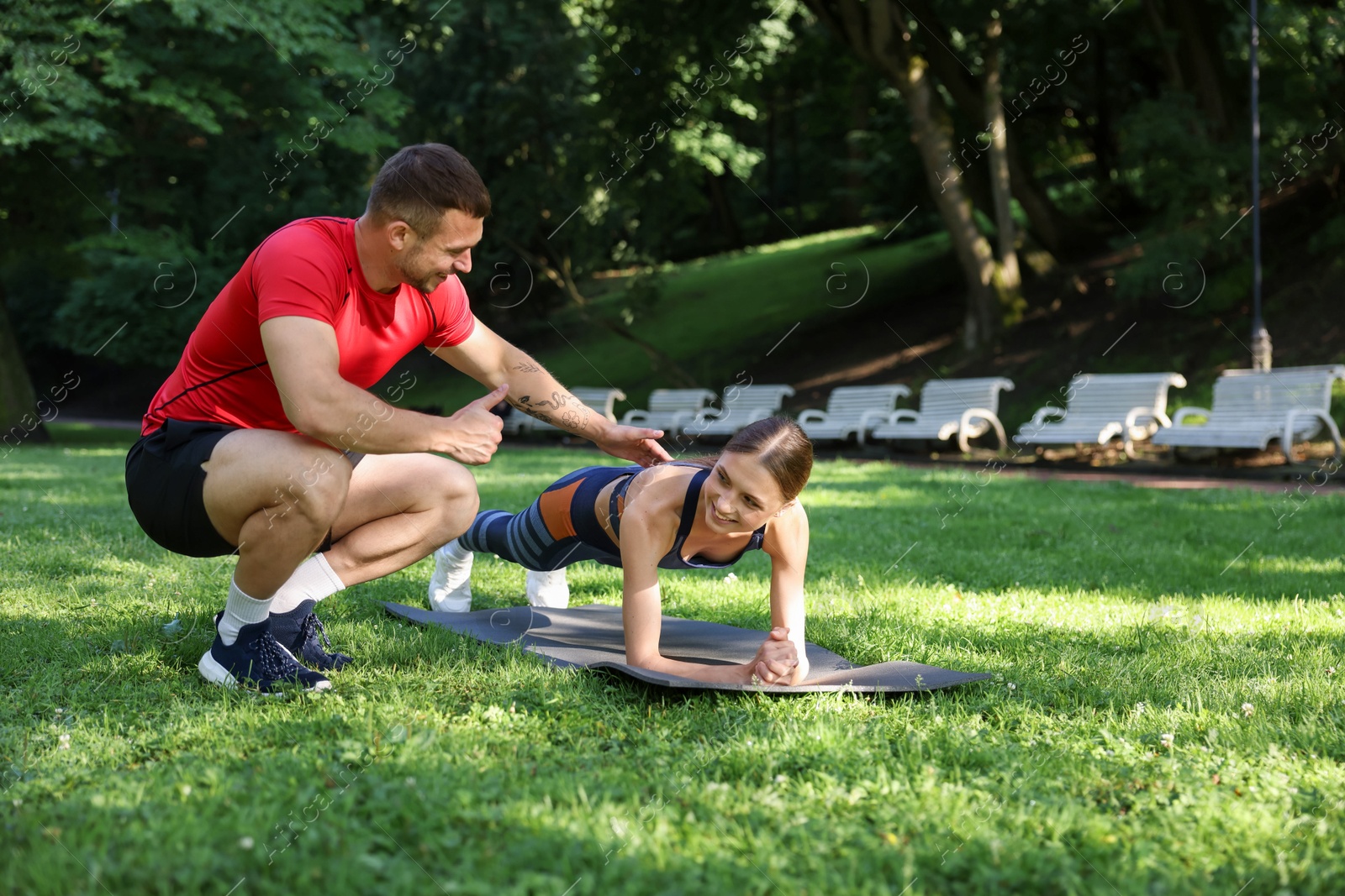 Young woman exercising with professional personal trainer outdoors. Space for text Photo of Young woman exercising with professional personal trainer outdoors. Space for text