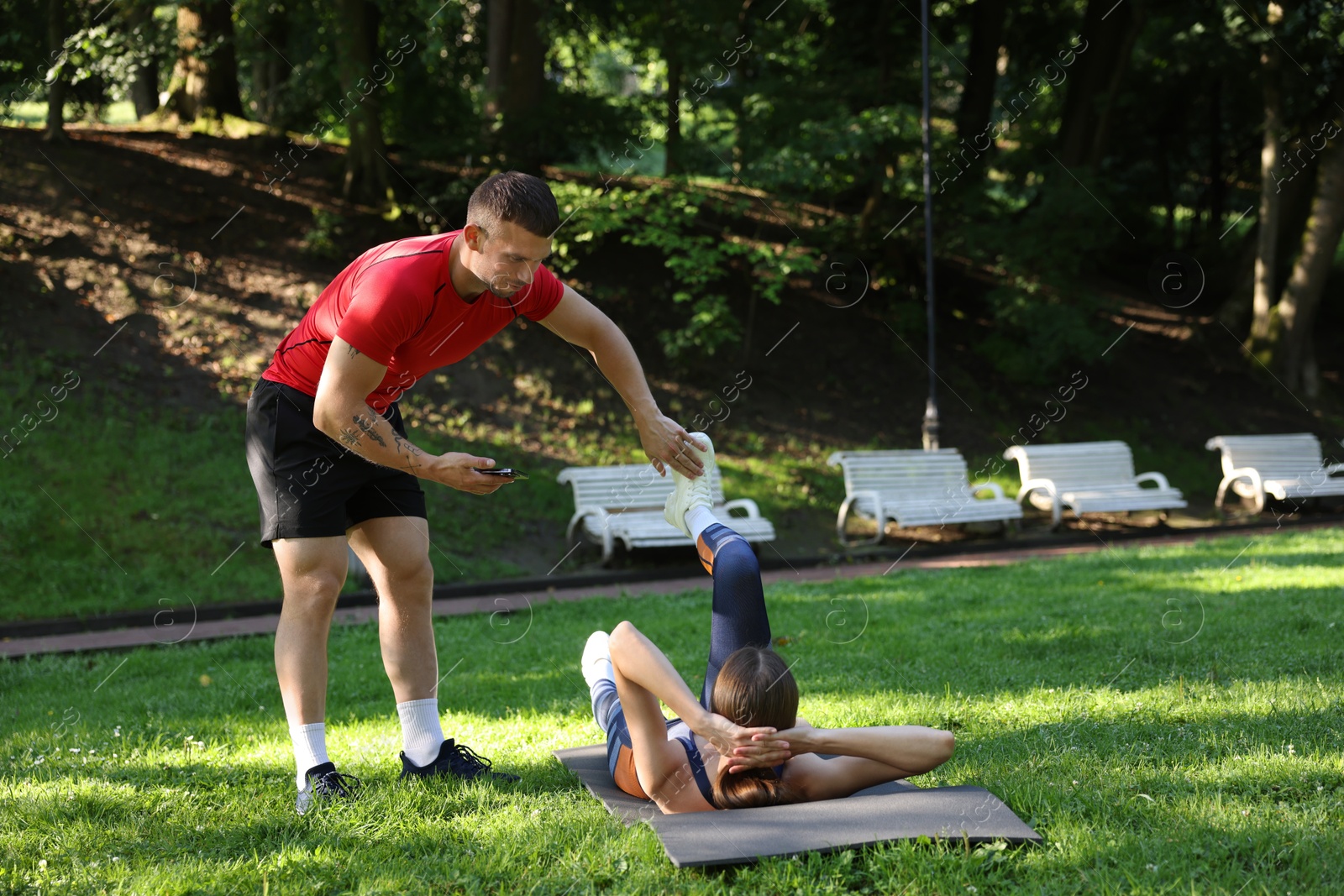 Young woman exercising with professional personal trainer outdoors. Space for text Photo of Young woman exercising with professional personal trainer outdoors. Space for text