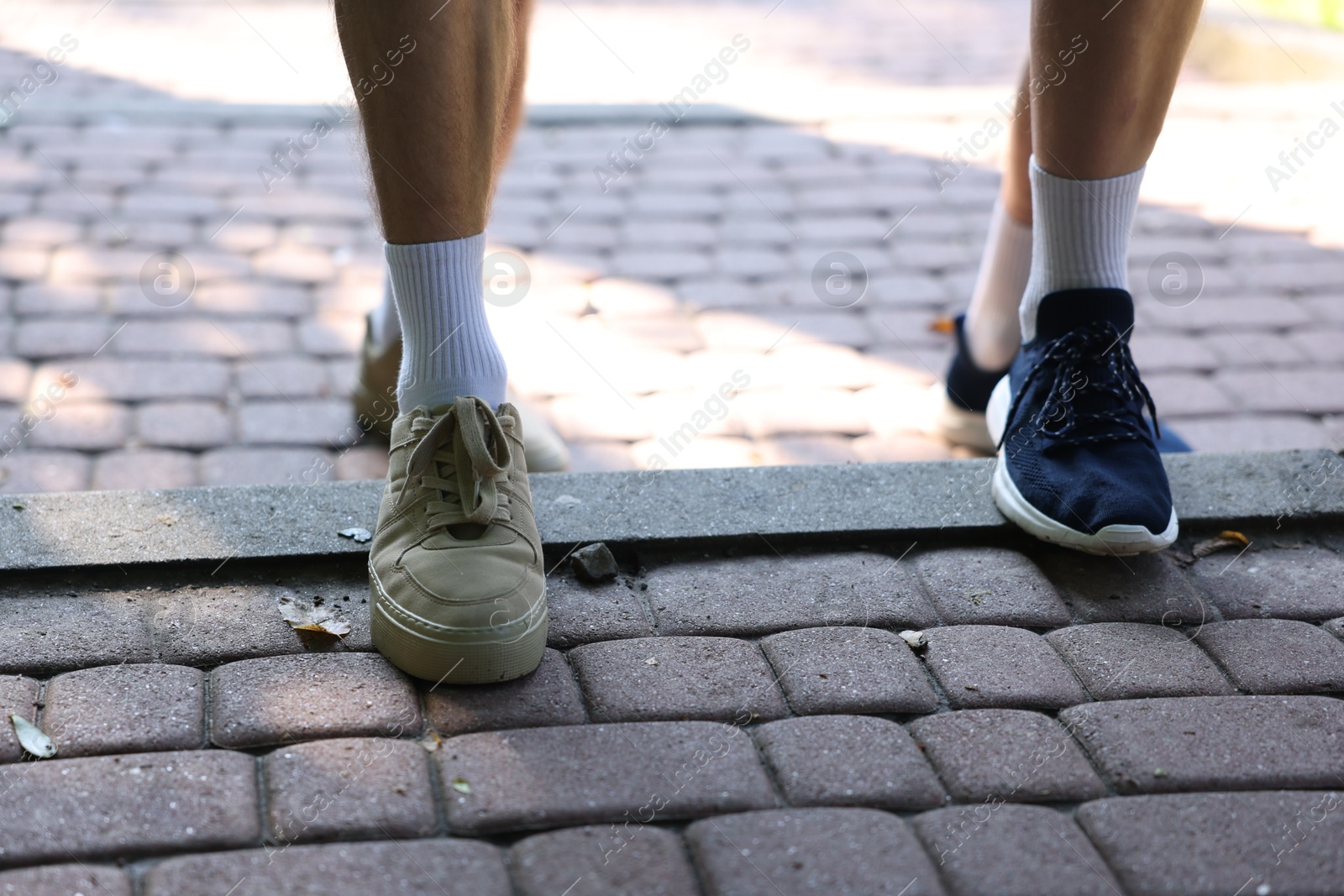 Photo of Young man running with professional personal trainer outdoors, closeup