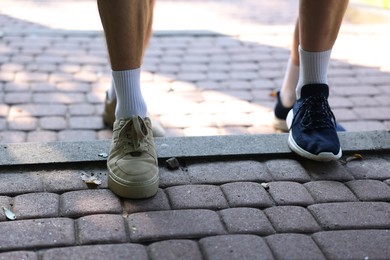 Photo of Young man running with professional personal trainer outdoors, closeup