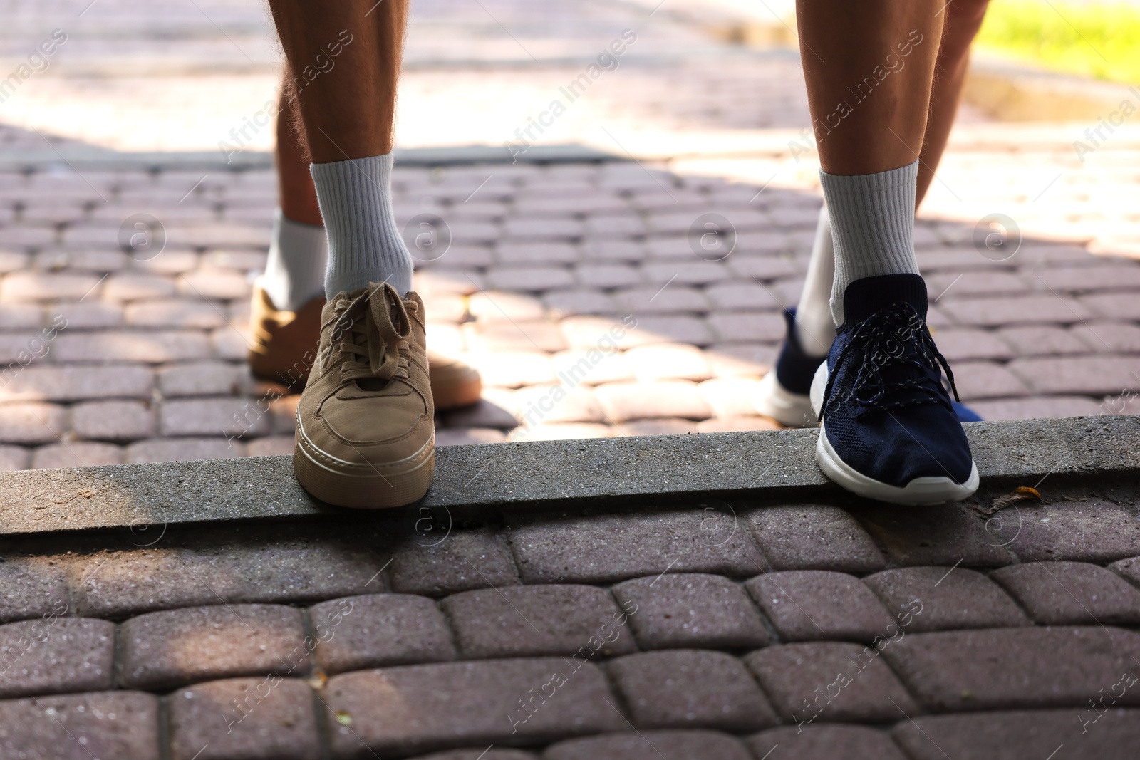 Photo of Young man running with professional personal trainer outdoors, closeup