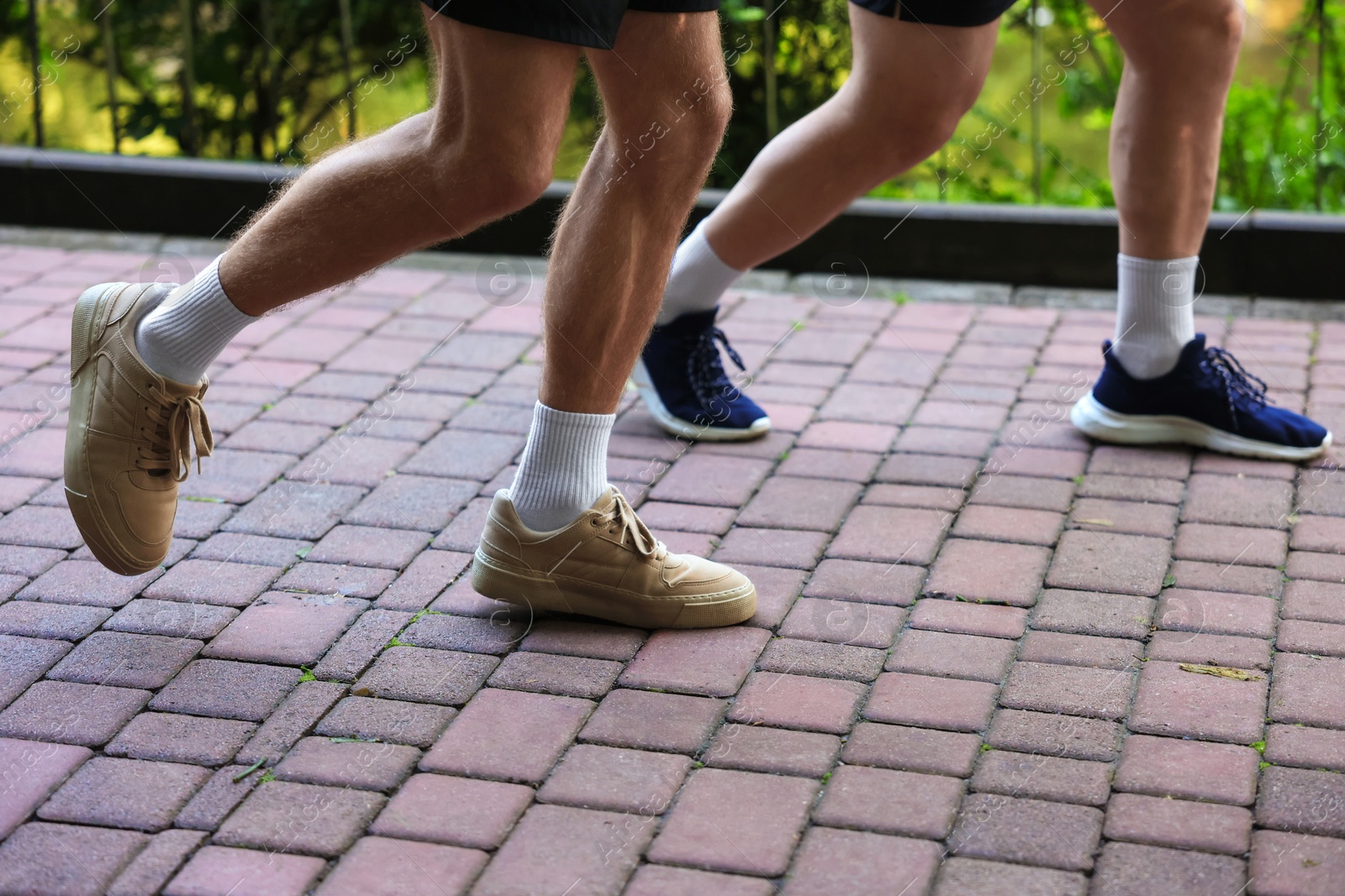 Young man running with professional personal trainer outdoors, closeup Photo of Young man running with professional personal trainer outdoors, closeup