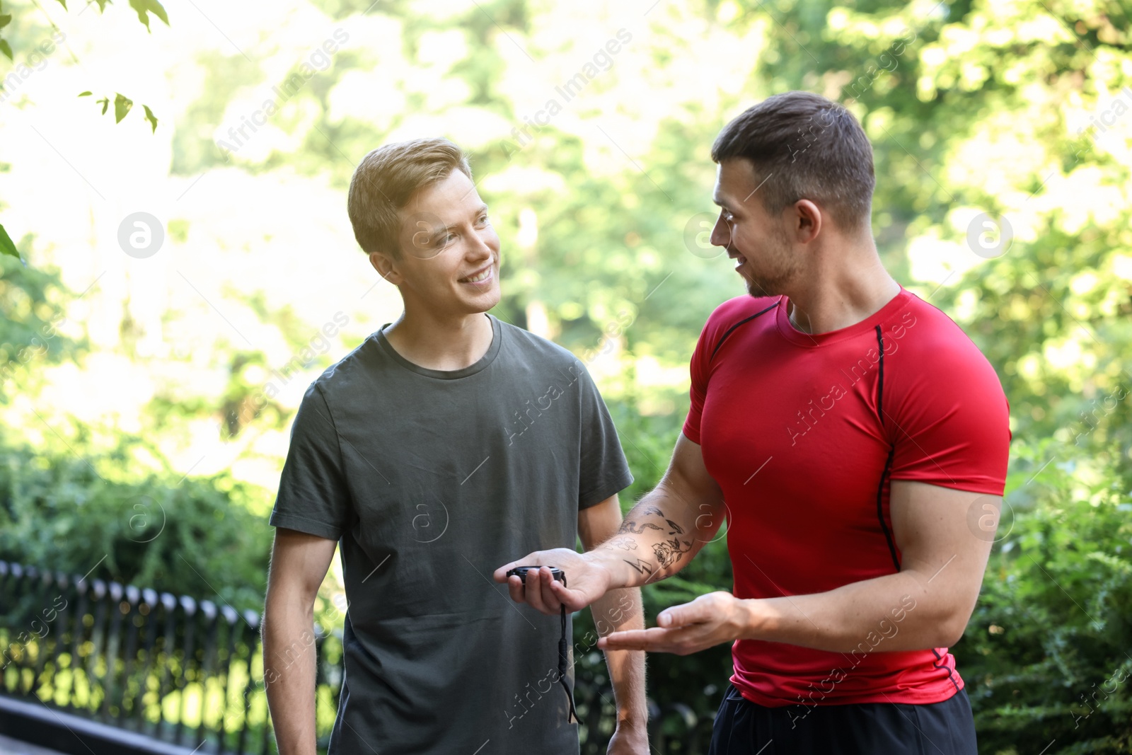 Young man with professional personal trainer outdoors Photo of Young man with professional personal trainer outdoors