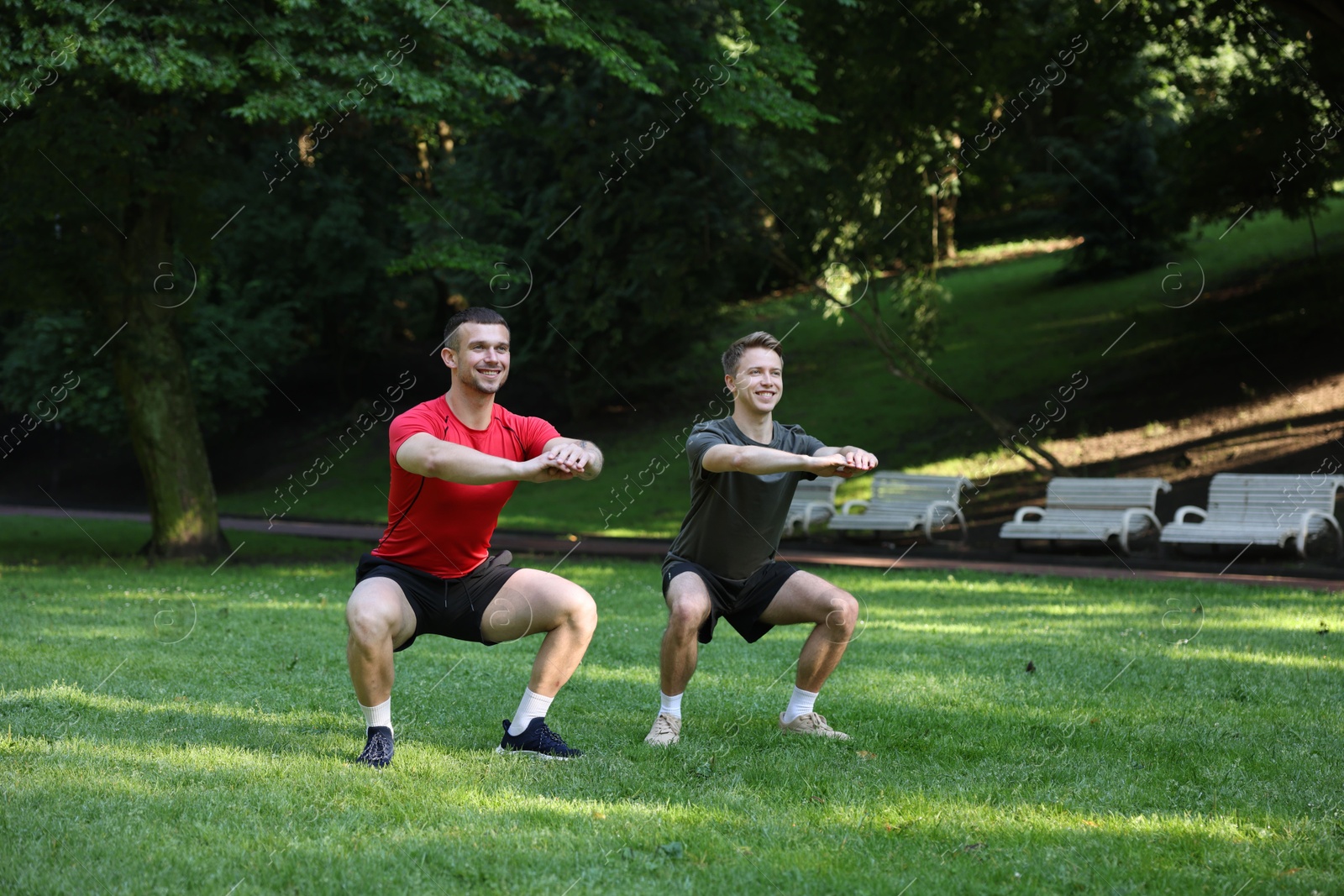 Photo of Young man exercising with professional personal trainer outdoors