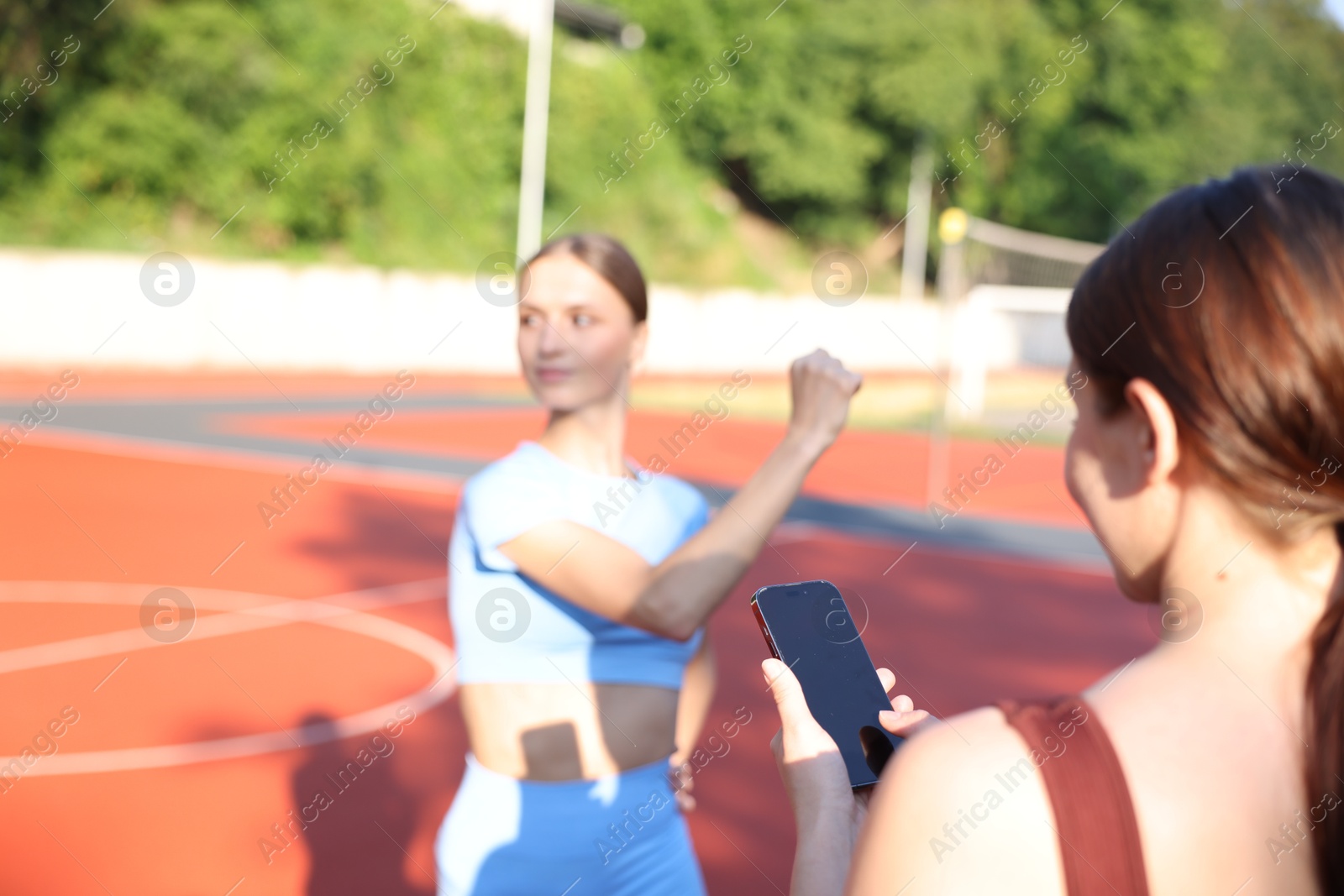 Young woman exercising with professional personal trainer outdoors, selective focus Photo of Young woman exercising with professional personal trainer outdoors, selective focus