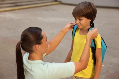 Photo of Mother taking her son to school outdoors
