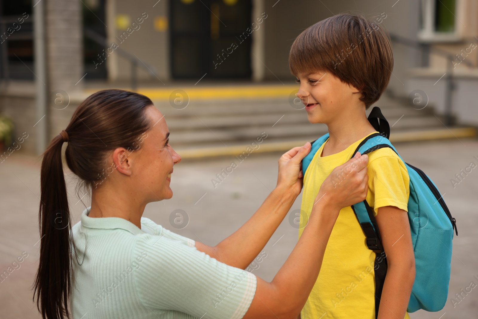 Photo of Mother taking her son to school outdoors