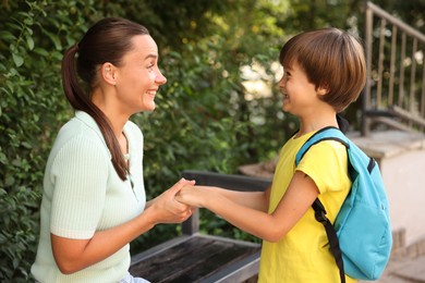 Photo of Mother taking her son to school outdoors