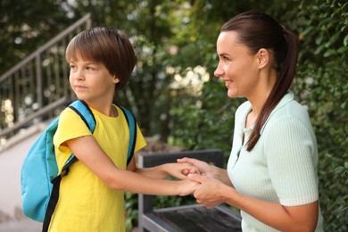 Photo of Mother taking her son to school outdoors