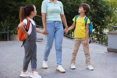 Photo of Mother taking her children to school outdoors, closeup