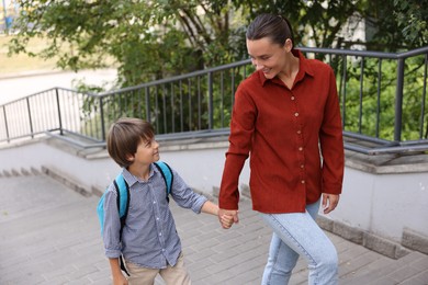 Photo of Mother taking her son to school outdoors