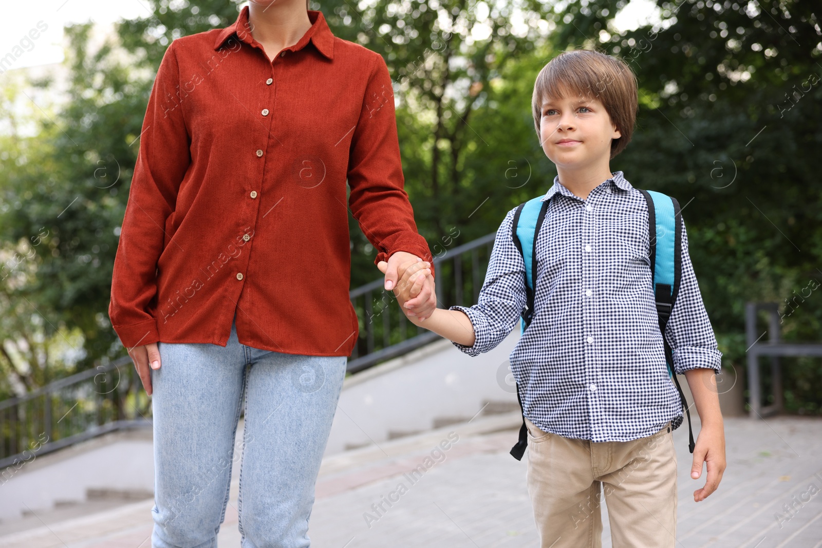 Photo of Mother taking her son to school outdoors, closeup