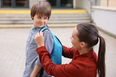 Photo of Mother taking her son to school outdoors