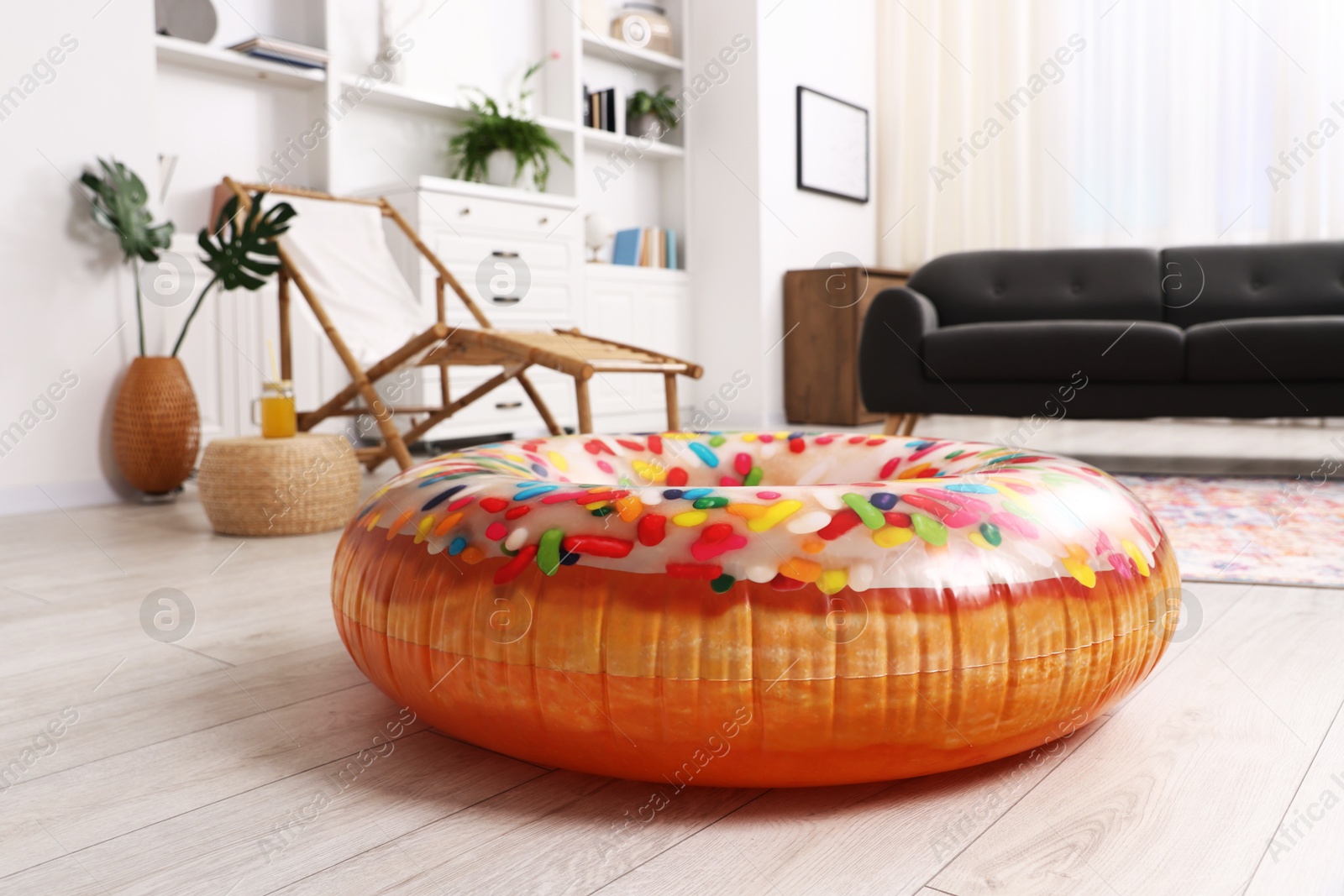 Bright inflatable donut shaped ring on wooden floor indoors. Dreaming about vacation at sea Photo of Bright inflatable donut shaped ring on wooden floor indoors. Dreaming about vacation at sea