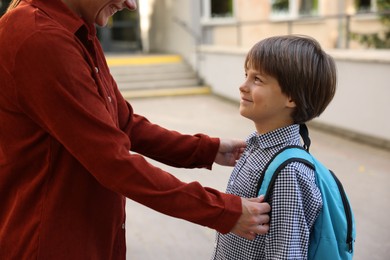 Photo of Mother taking her son to school outdoors, closeup