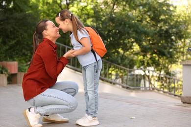 Photo of Mother taking her daughter to school outdoors, space for text