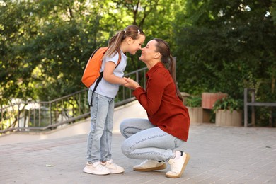Photo of Mother taking her daughter to school outdoors