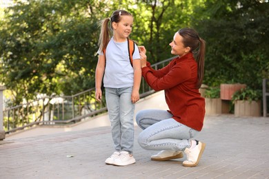 Photo of Mother taking her daughter to school outdoors