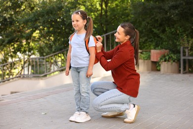 Photo of Mother taking her daughter to school outdoors