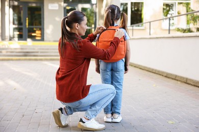 Photo of Mother taking her daughter to school outdoors