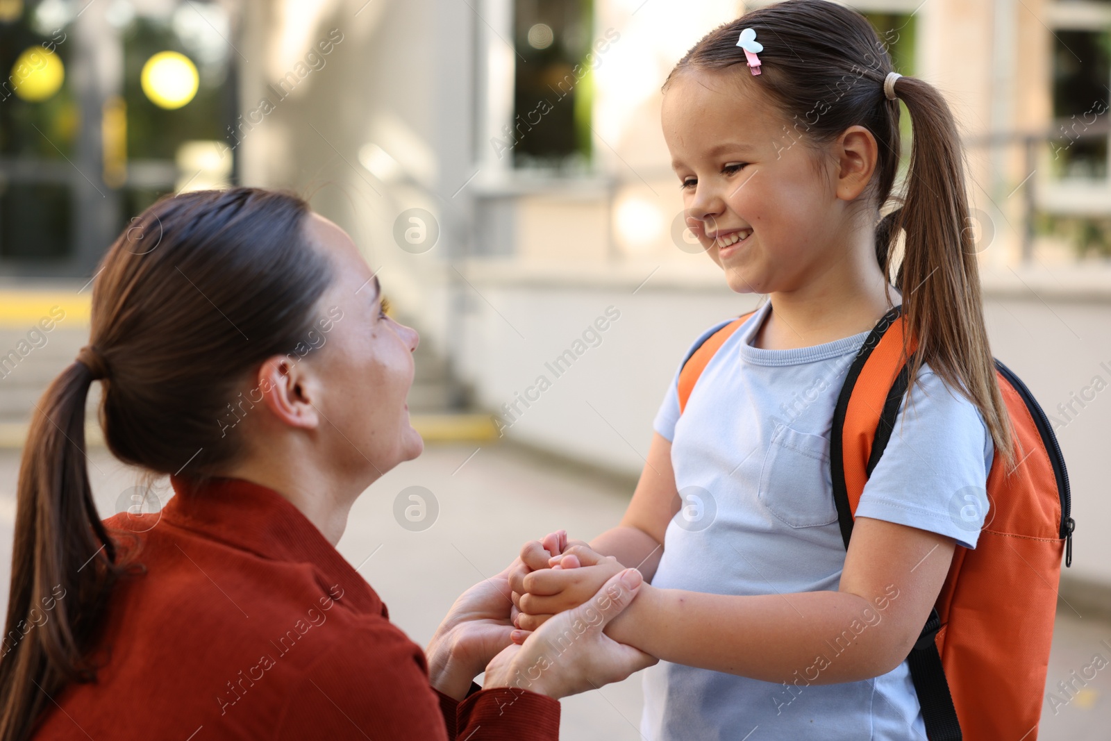 Mother taking her daughter to school outdoors Photo of Mother taking her daughter to school outdoors