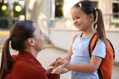 Photo of Mother taking her daughter to school outdoors