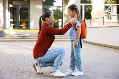 Photo of Mother taking her daughter to school outdoors