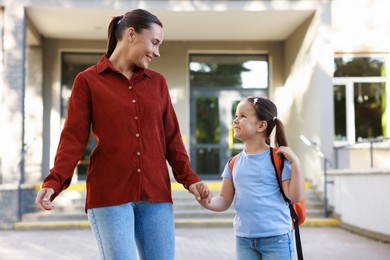 Photo of Mother taking her daughter to school outdoors