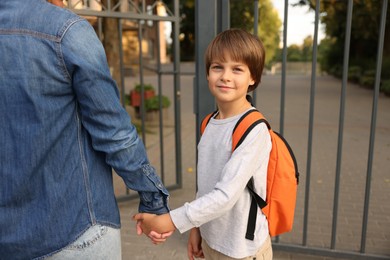Photo of Mother taking her son to school outdoors, closeup