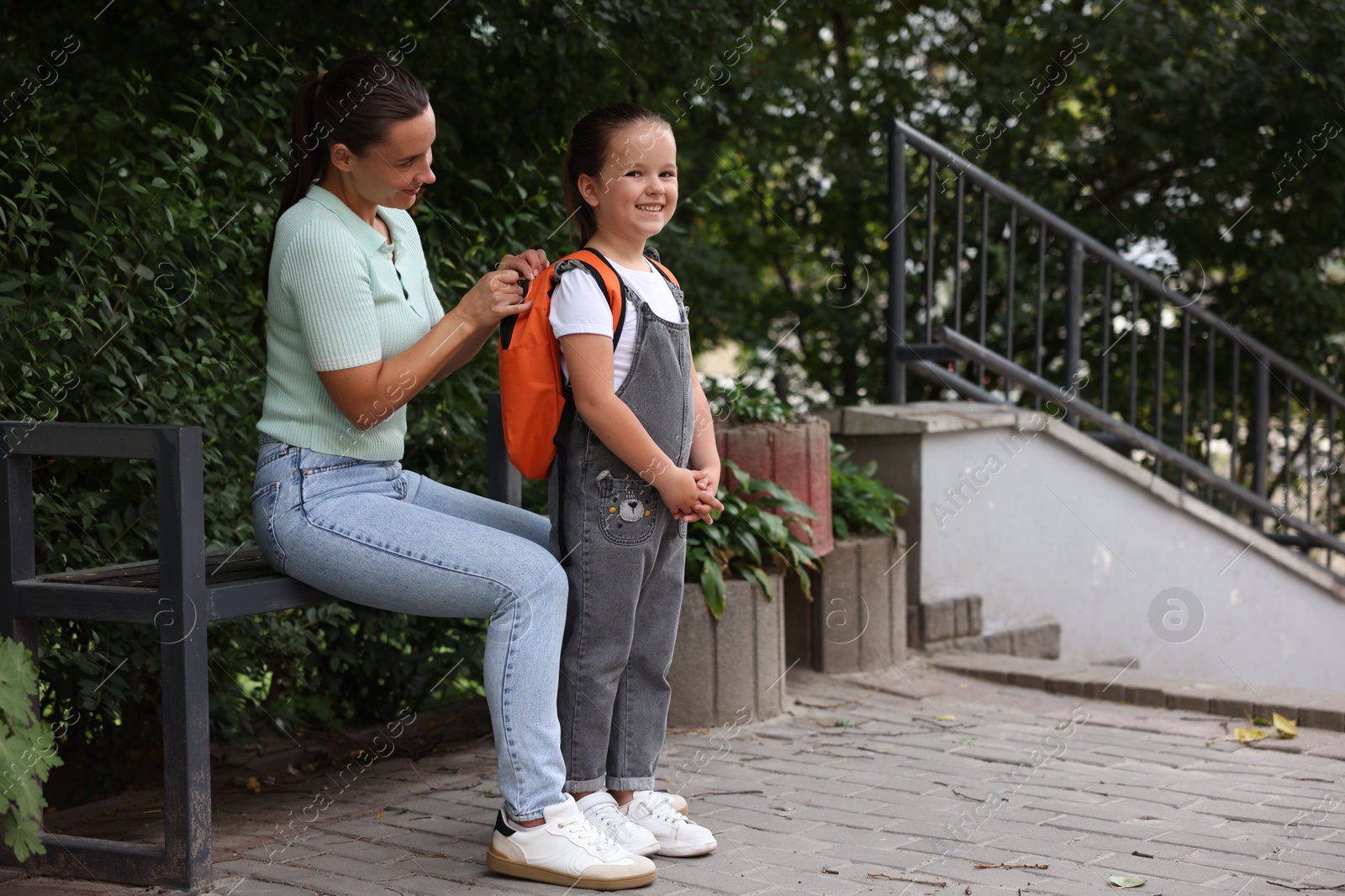 Mother taking her daughter to school outdoors Photo of Mother taking her daughter to school outdoors