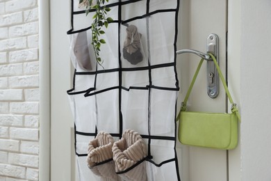 Photo of Organizer with different stuff on door indoors, closeup