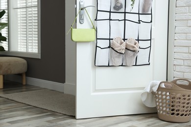 Photo of Organizer with different stuff on door and basket indoors
