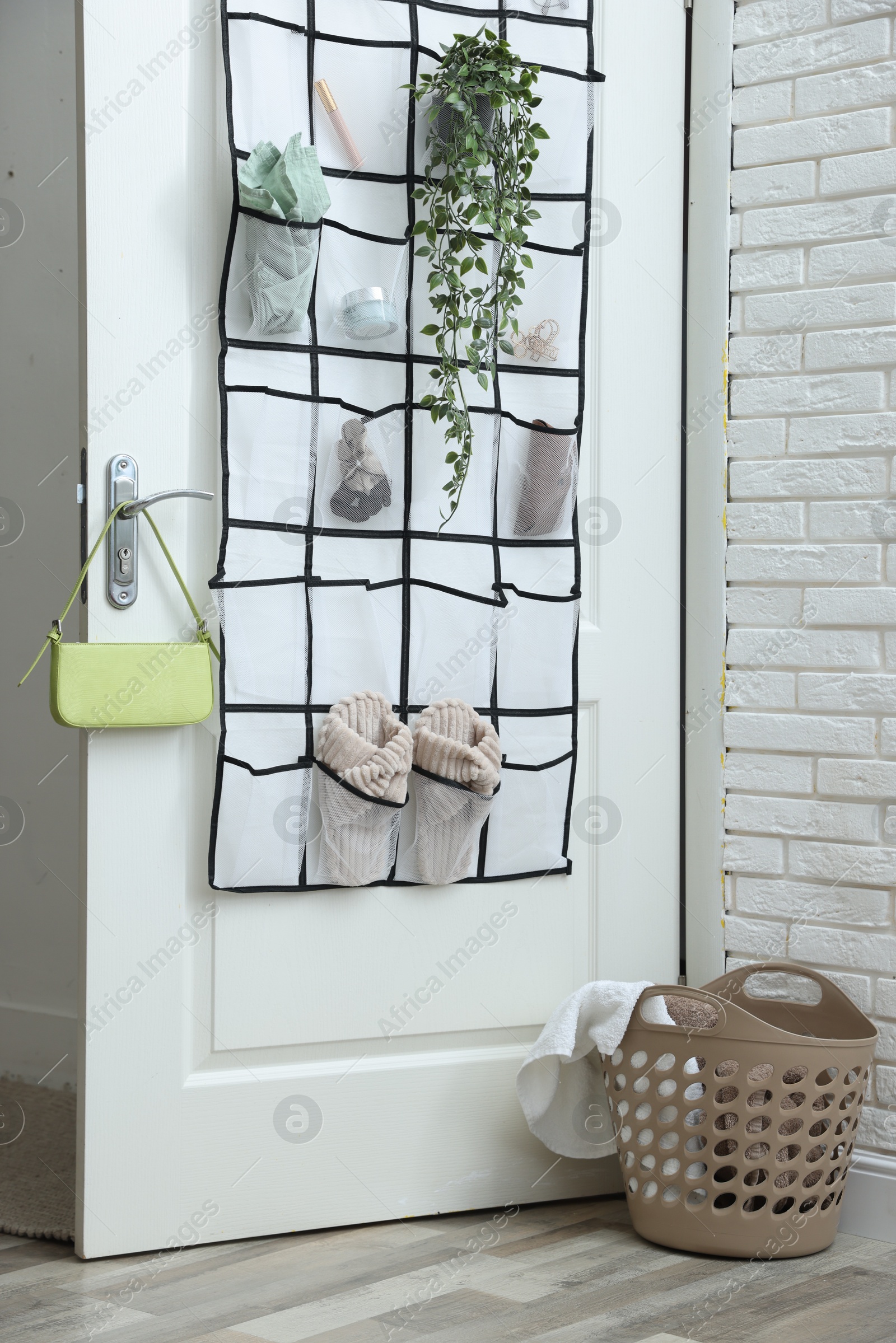 Organizer with different stuff on door and basket indoors Photo of Organizer with different stuff on door and basket indoors
