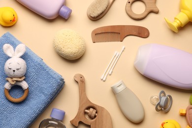 Photo of Baby bath accessories and teethers on beige background, flat lay